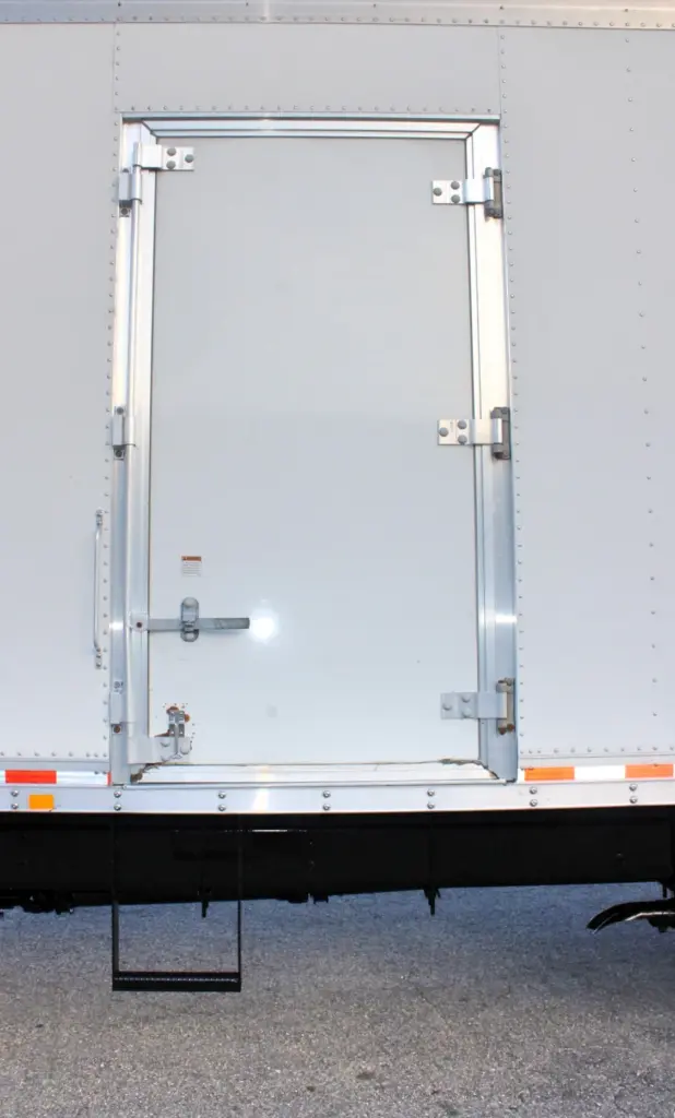 2020 Freightliner M2 106 — close view of closed white rear swing door with silver hinges, latch handle and rear step below