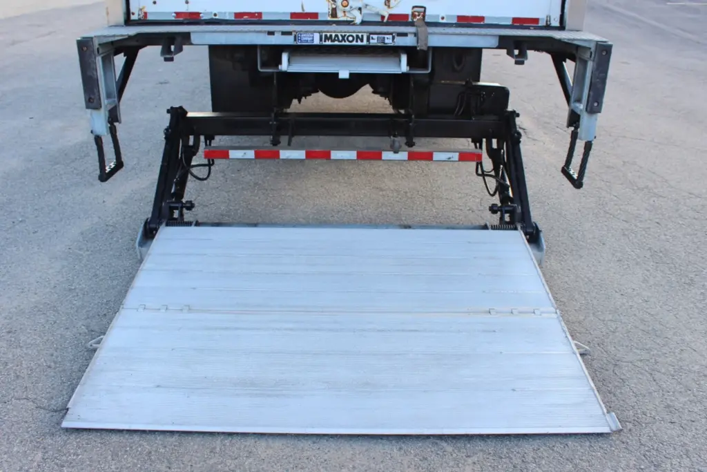 2020 Freightliner M2 106 — rear view of lowered tail lift platform with red and white reflective bar above, white box body