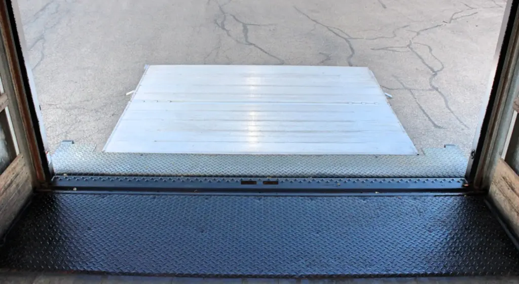 2020 Freightliner M2 106 — view out the open rear doorway over diamond plate floor to a white aluminum ramp on pavement