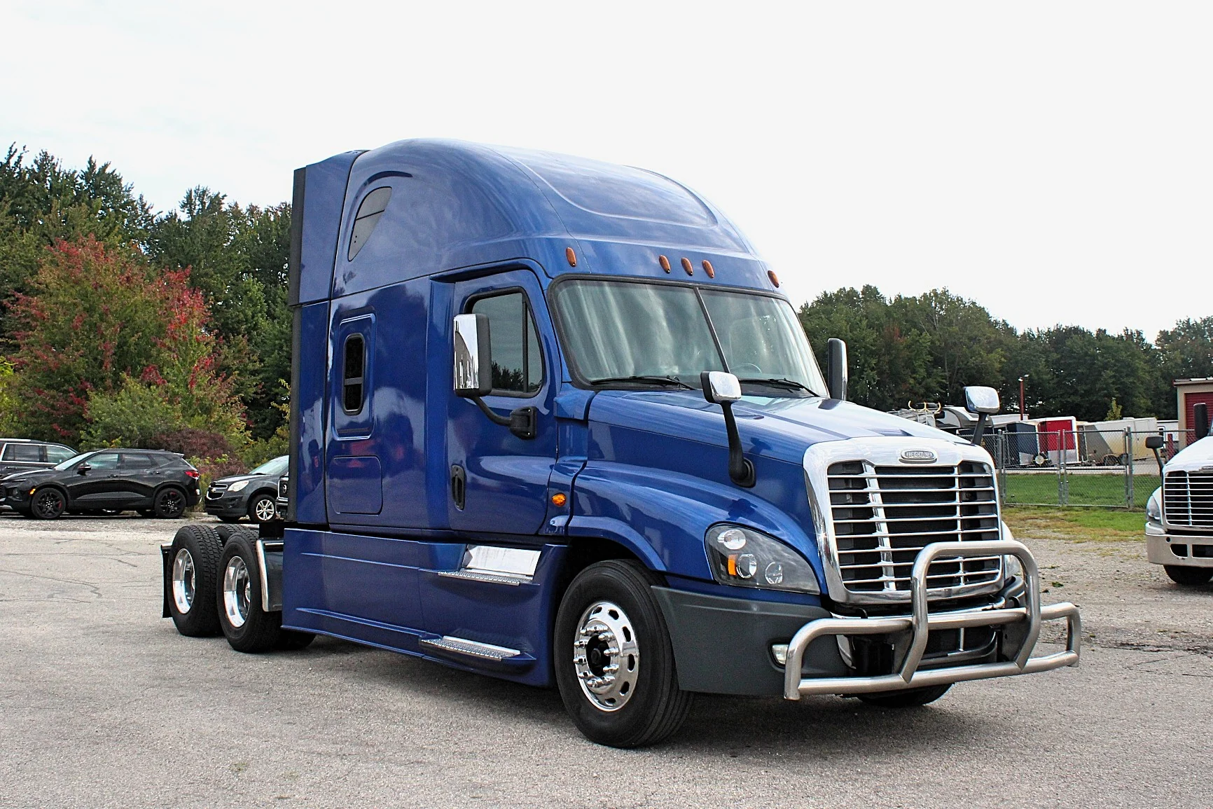 2020 Freightliner Cascadia 125 Glider – blue sleeper semi truck front three-quarter exterior view with chrome grille guard.
