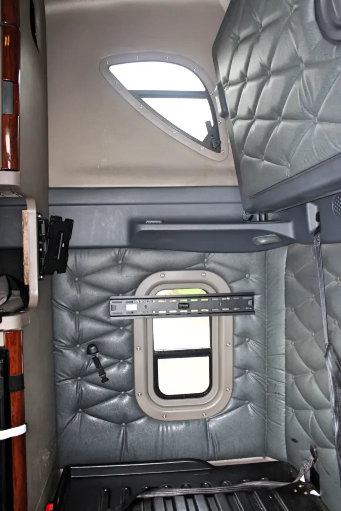 2020 Freightliner Cascadia 125 Glider – sleeper compartment with padded wall panels, side window and bunk area.