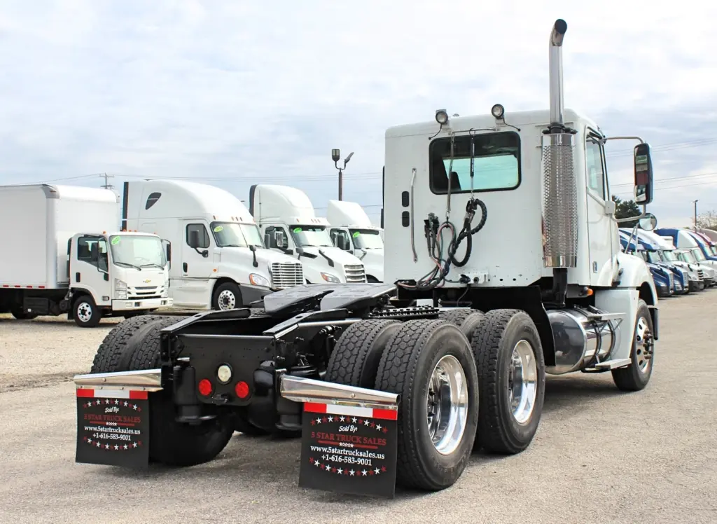 2020 Freightliner Columbia 120 — rear three-quarter view of white day cab with dual aluminum rear wheels and chrome stack.