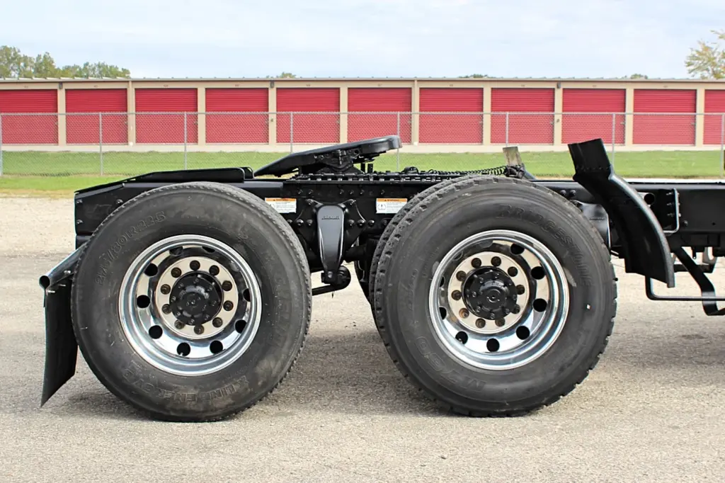2020 Freightliner Columbia 120 — low side angle of rear drive axles with dual aluminum wheels on a black chassis.