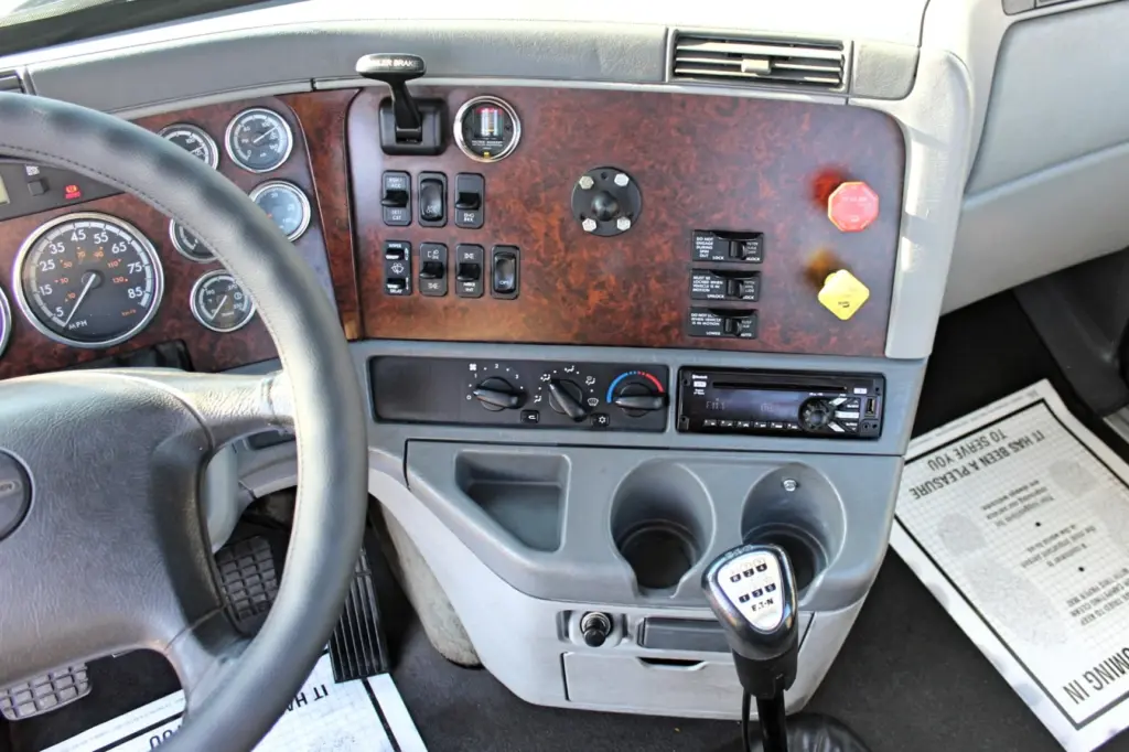 2020 Freightliner Columbia 120 — dash-level view of burl panel, 10-speed shifter knob and climate controls by cup holders