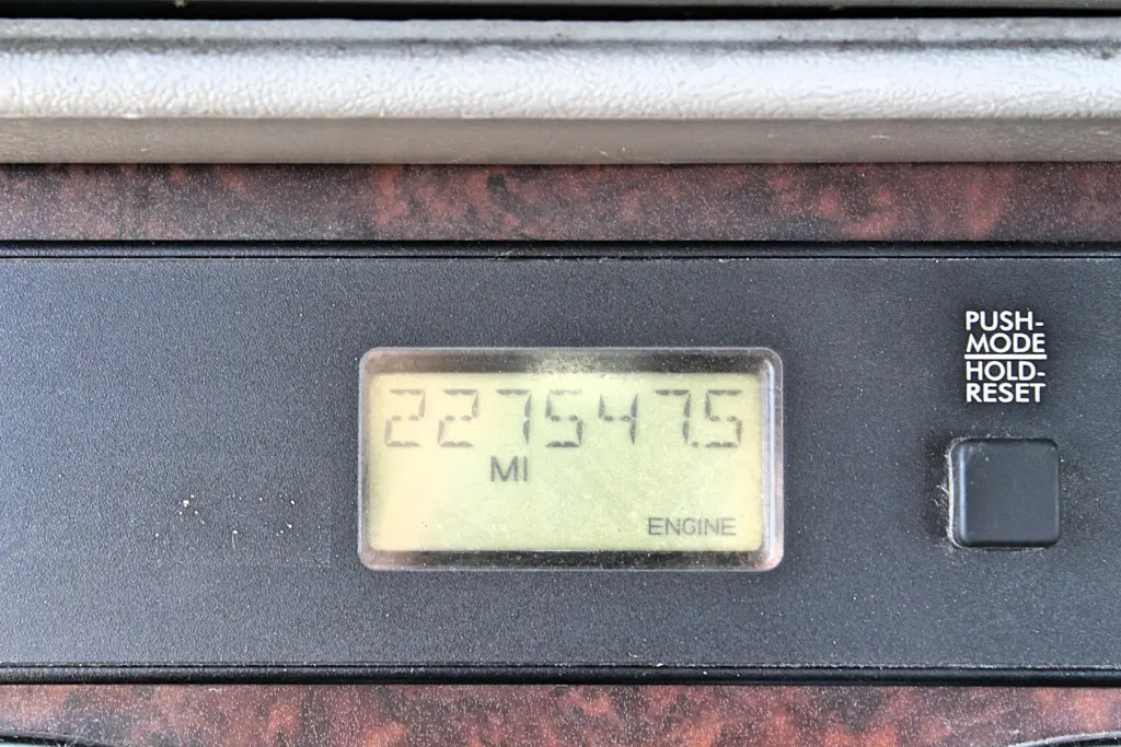 2020 Freightliner Columbia 120 — close-up of digital odometer in miles beside the ENGINE light and push-mode reset button.