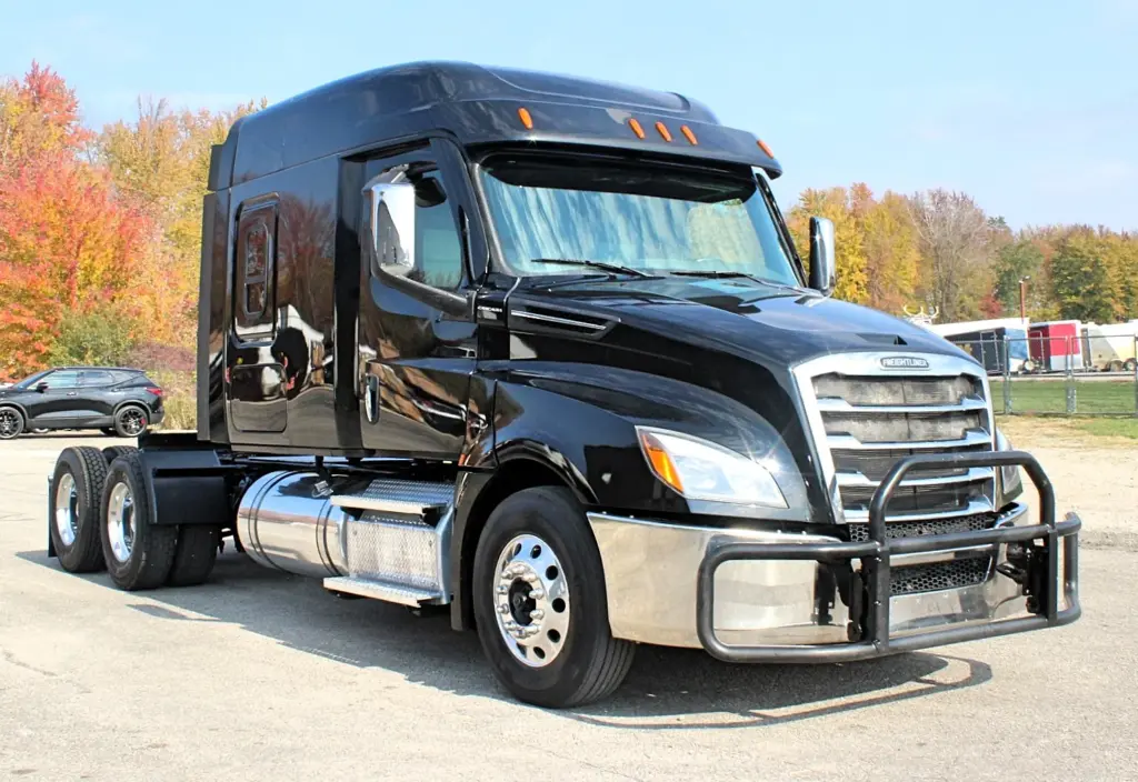 2021 Freightliner Cascadia 126 — front three-quarter view of black sleeper tractor with chrome grille and aluminum wheels