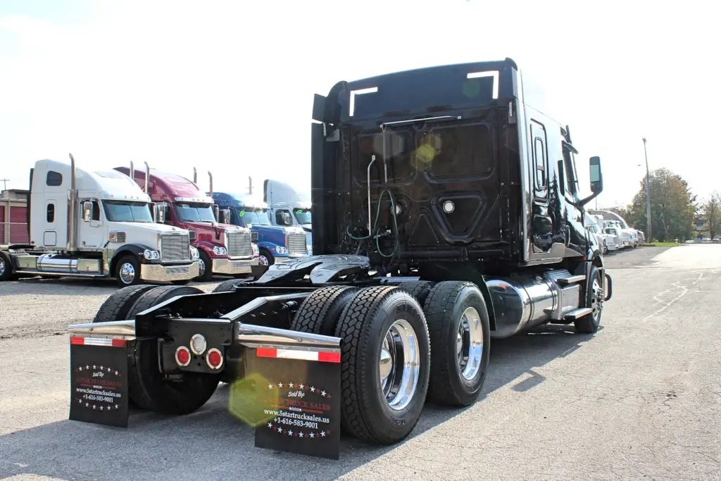 2021 Freightliner Cascadia 126 — rear three-quarter view of black sleeper tractor showing sleeper back and polished wheels