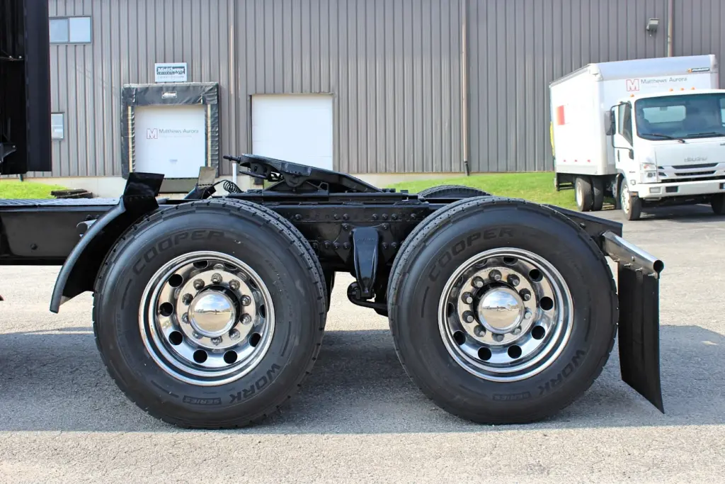 2021 Freightliner Cascadia 126 — curbside view of tandem drive tires with Cooper Work Series tread and polished wheels