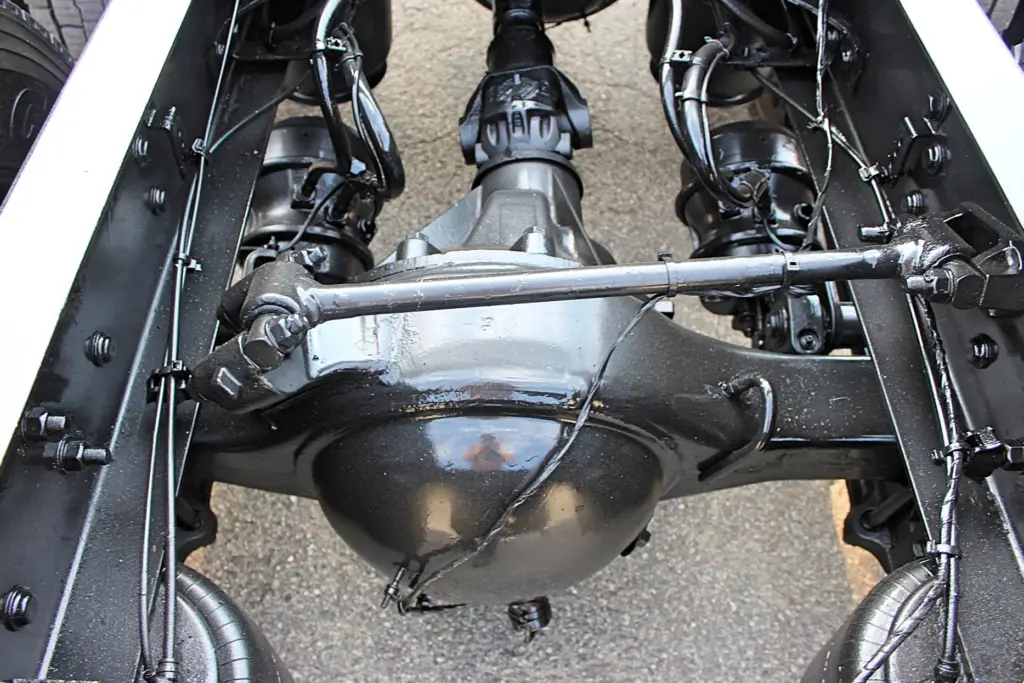 2021 Freightliner Cascadia 126 — low underside view of black drive axle with differential, driveshaft yoke and torque rod