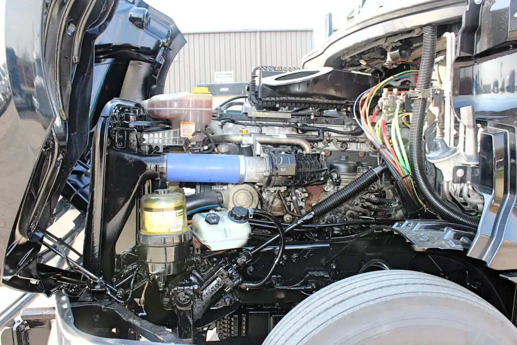 2021 Freightliner Cascadia 126 — side angle of the DD15 engine with blue intake hose, yellow filter and wiring harness