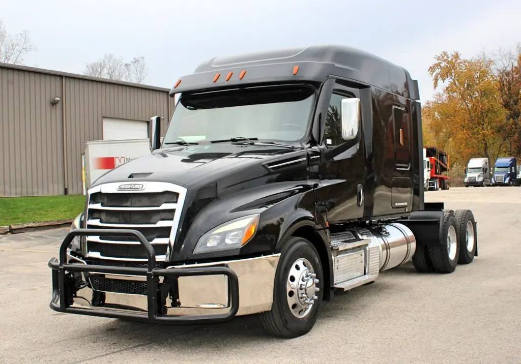 2021 Freightliner Cascadia 126 — black sleeper tractor nearly head-on with brush guard and polished steer wheel.