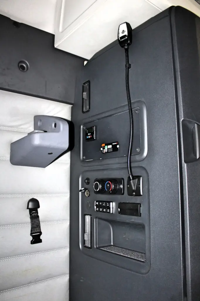 2021 Freightliner Cascadia 126 — side-angle view of dash panel with HVAC knobs, gooseneck mic and belt