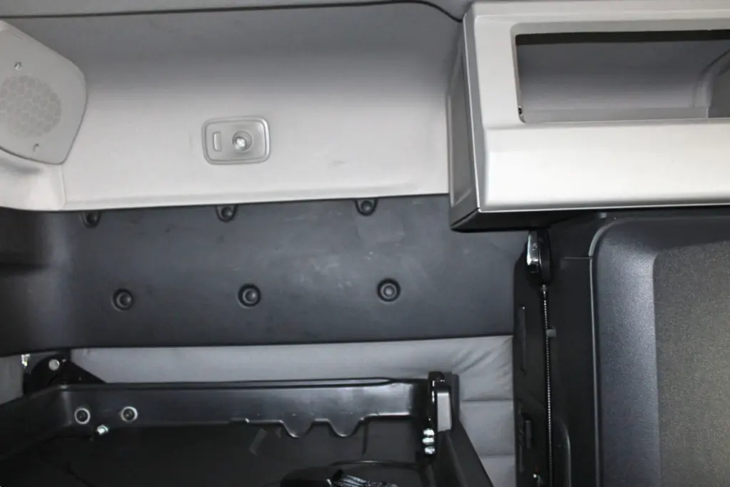 2021 Freightliner Cascadia 126 — close view of gray dash trim with speaker grille, a switch plate and black lower panel.